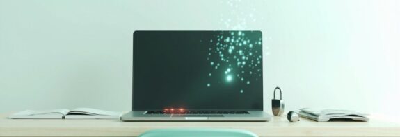 Portatil abierto en un escritorio con una llave y un candado metalico al lado, representando el robo de credenciales de herramientas de IA por malware