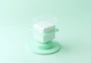 Cubo contenedor blanco envuelto en una celda transparente menta representando aislamiento de sandbox