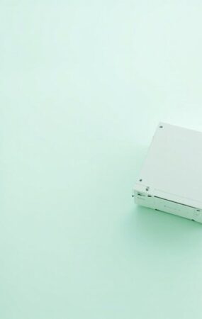 Render 3D editorial de un servidor rack de 1U visto desde arriba sobre una superficie clara con acentos verde menta, sin texto ni logotipos visibles.