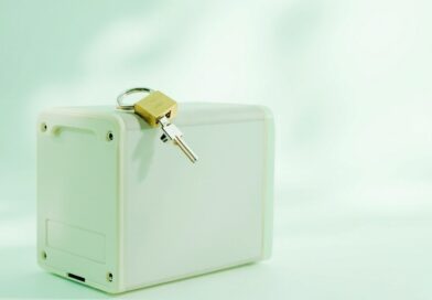 Caja blanca de un servidor con un candado dorado sobre la tapa, sobre fondo claro en tonos verde menta y blanco